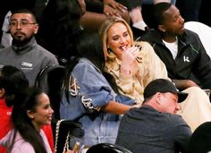 a woman sitting in the stands at a basketball game with other people behind her looking on