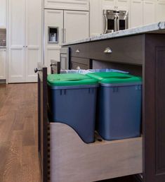 two blue bins are in the middle of a kitchen island