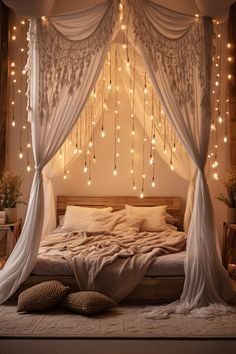 a canopy bed with lights hanging from it's sides and pillows on the floor