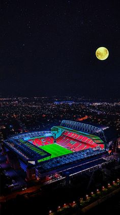 an aerial view of a stadium at night with the moon in the sky above it