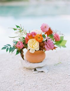 a vase filled with flowers sitting on top of a rock