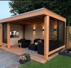 a small backyard with a tv on the wall and couches in front of it