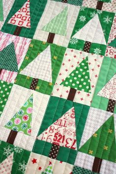 a quilted christmas tree is shown on the table topper, with green and red trees