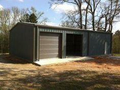 two garages in the middle of a field with trees