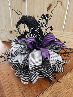 a purple and black wreath on top of a wooden table