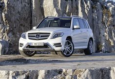 a white mercedes glk parked in front of a rocky cliff face with the number plate on it