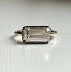 an emerald cut diamond sits on a white surface