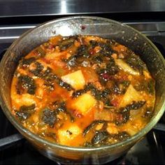 a glass bowl filled with food sitting on top of a stove