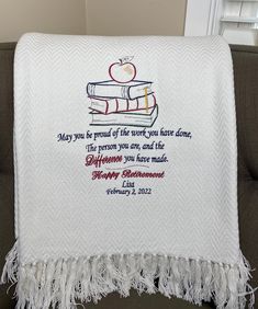 a white blanket with an apple and books on it that says, may you be proud of the work you have done