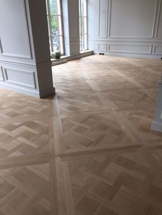 an empty room with wooden floors and white walls