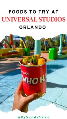 a person holding up a bucket of food with the words, foods to try at universal studios orlando