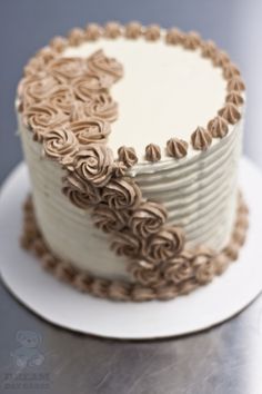 a cake with white frosting and brown swirls