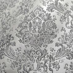 an ornate silver background with black and white designs on it's fabric, which is very