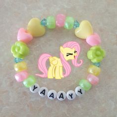 a bracelet with the word may written in white letters and a pink pony on it