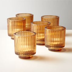 four yellow glass cups sitting on top of a table