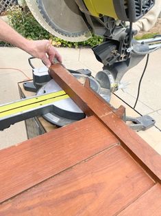 a person using a circular saw to cut wood