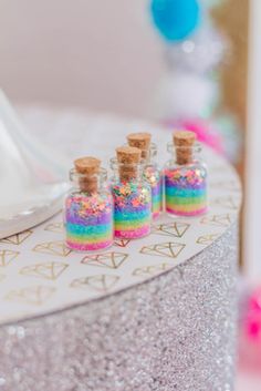 small bottles filled with colorful confetti and sprinkles on top of a table