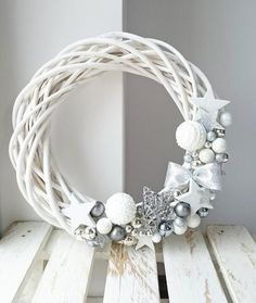 a white wreath with silver ornaments on it