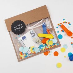 a birthday card with confetti, scissors and money in it on a table