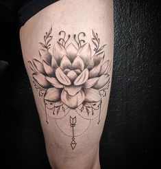 a black and white photo of a flower tattoo on the right leg, with an arrow in the middle