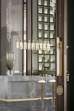 an elegant bathroom with marble counter tops and gold accents, chandelier in the background