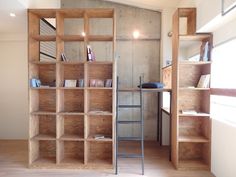 an open book shelf in the corner of a room with wooden shelves and metal ladder