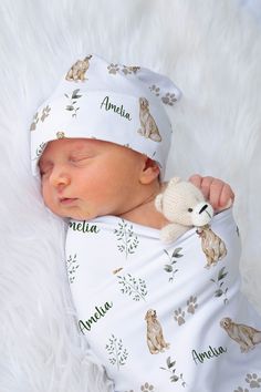 a newborn baby wearing a white hat and holding a teddy bear