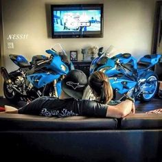 a woman laying on the floor in front of several parked motorbikes and a television