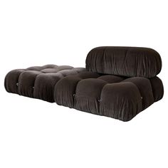 the reclining couch is made from dark brown velvet and has buttons on it's sides