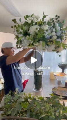 a man is arranging flowers in a vase