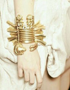 a close up of a person's arm wearing gold bracelets