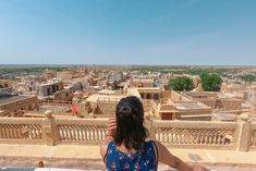 a woman standing on top of a roof looking at the city