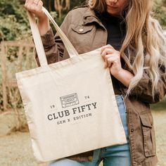 a woman holding a bag that says club fifty