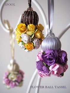 three flower ball ornaments hanging from a hook