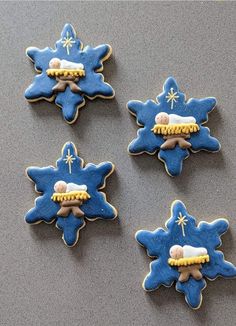 four decorated cookies with icing on top of a table