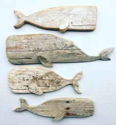 three pieces of wood carved to look like whale's, each with different shapes and sizes