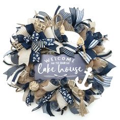 a welcome sign is attached to a wreath made out of burlocks and ribbons