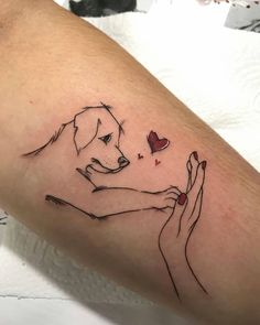 a woman's arm with a dog holding a heart