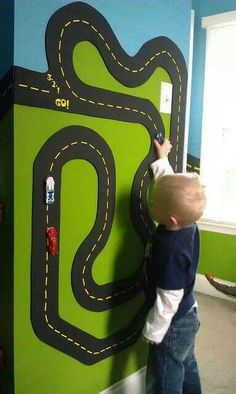 a young boy is playing with a toy race track