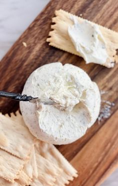 a wooden cutting board topped with cheese and crackers