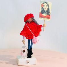 a doll holding a sign on top of a table