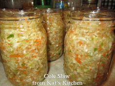 three jars filled with coleslaw sitting on top of a counter