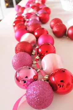 pink and red ornaments are lined up on a table