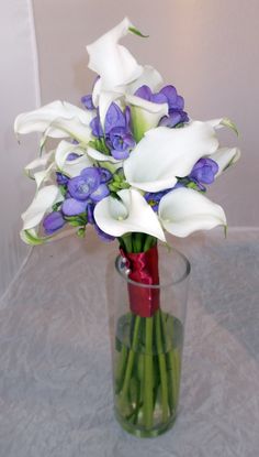 a vase filled with purple and white flowers