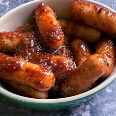 a bowl filled with chicken wings covered in bbq sauce