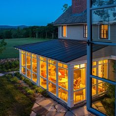 a house that is lit up at night with the lights on and windows showing outside