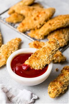 fried chicken sticks with ketchup in a white bowl