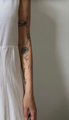 a woman with a tattoo on her arm holding a piece of paper in her hand