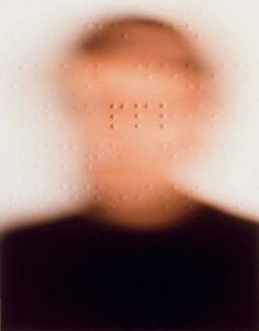 a blurry image of a man's face with small dots in the background