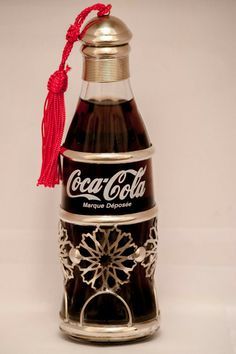 an old coca - cola bottle with a tassel hanging from it's top